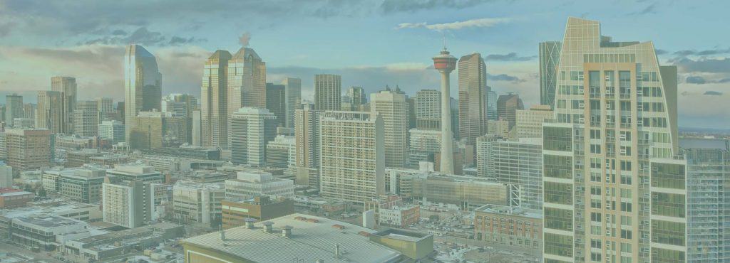 A city skyline featuring numerous modern high-rise buildings and skyscrapers under a partly cloudy sky, with the Calgary Tower visible among the structures—much like how website builders help create impressive digital landscapes. - Clio Websites | Top Canadian Web Design Company