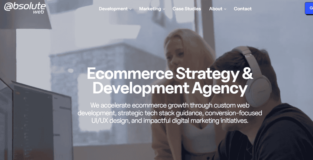 Two people work at computers in a modern office. Large white text reads, "Ecommerce Strategy & Development Agency," with details on e-commerce services and web design for companies. Website navigation is visible at the top. - Clio Websites | Top Canadian Web Design Company