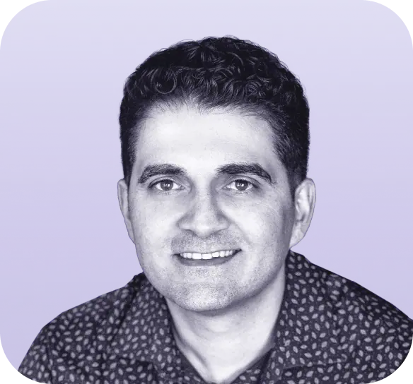 A person with short, dark, curly hair smiles at the camera. They are wearing a patterned shirt. The background is a gradient of light to medium purple. The image, perfect for Clio websites, is in black and white with a purple hue overlay. - Clio Websites | Top Canadian Web Design Company