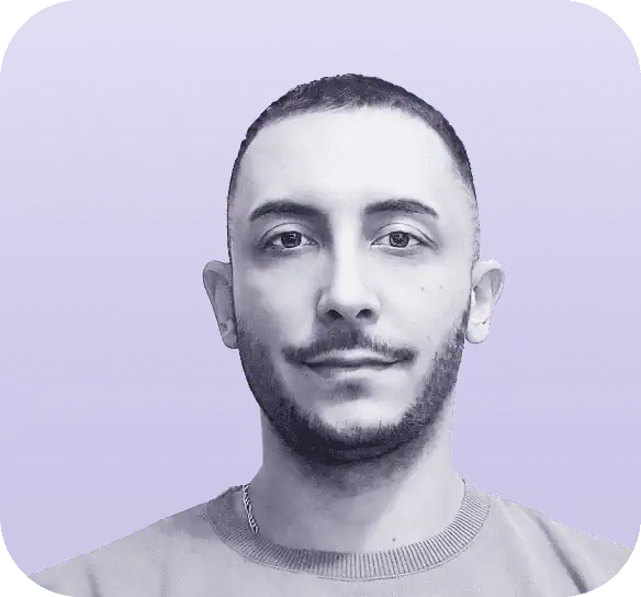 A man with short hair and a trimmed beard is looking directly at the camera against a purple gradient background, embodying the professionalism often featured on Clio websites. He is wearing a plain light-colored shirt, adding to his approachable demeanor. - Clio Websites | Top Canadian Web Design Company
